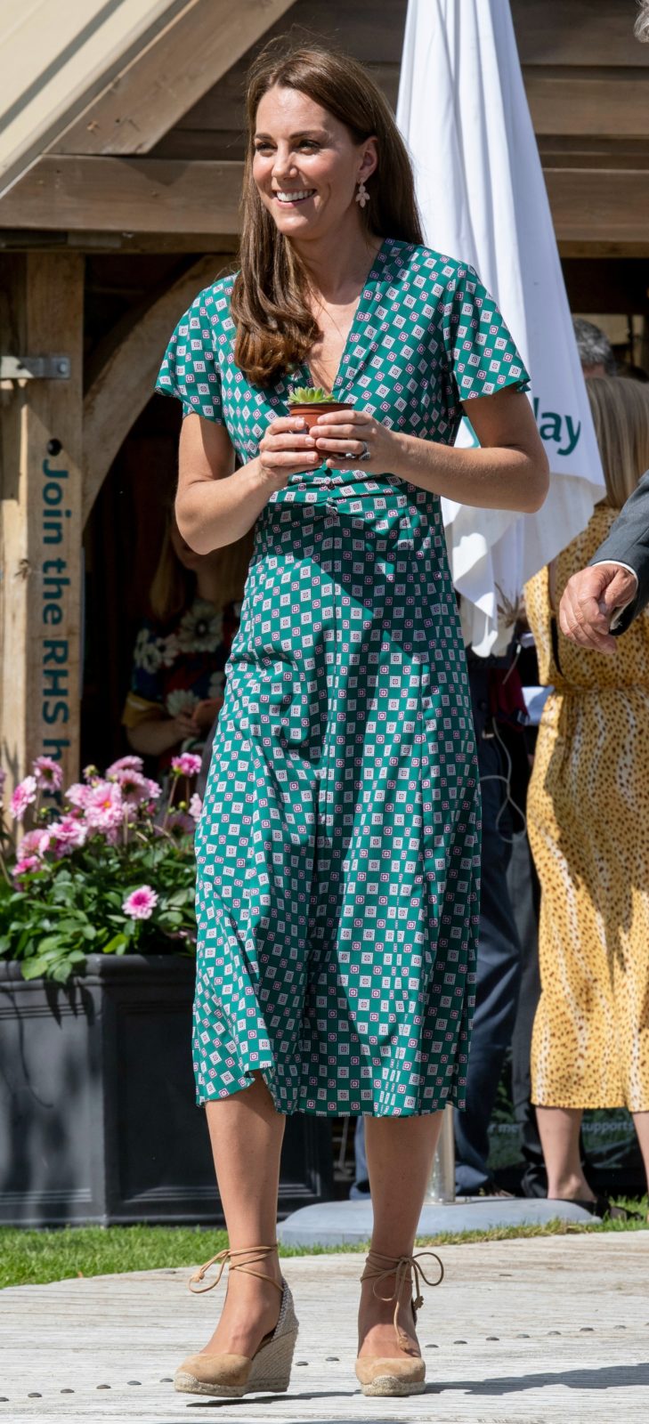 Gardening in style! Beaming Catherine towers in heels while playing ...