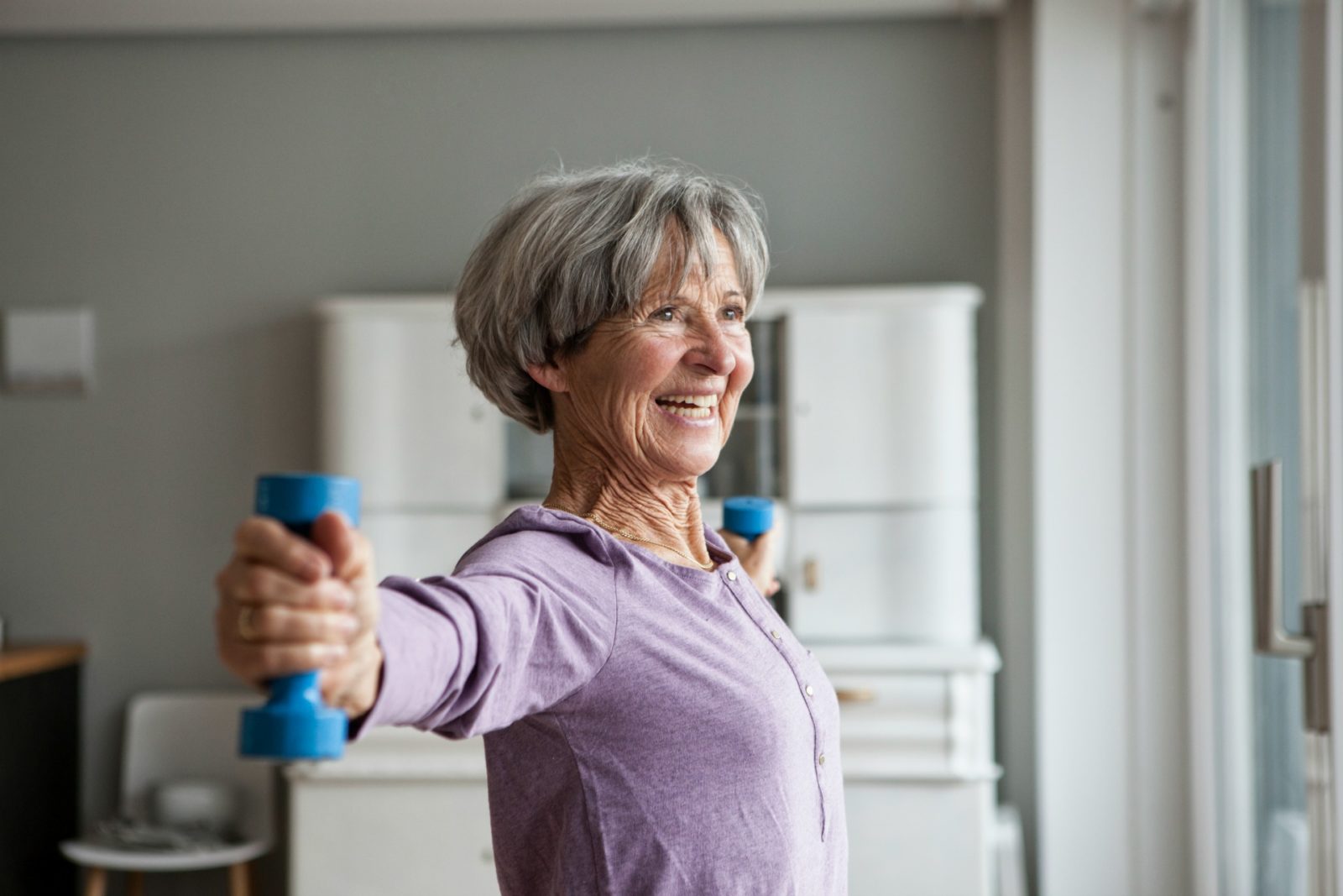 older-woman-lifting-weights-in-gym-stock-photo-dissolve