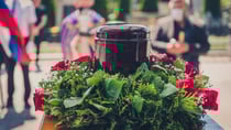 Funerary urn with ashes of dead and flowers at funeral. Image: Getty